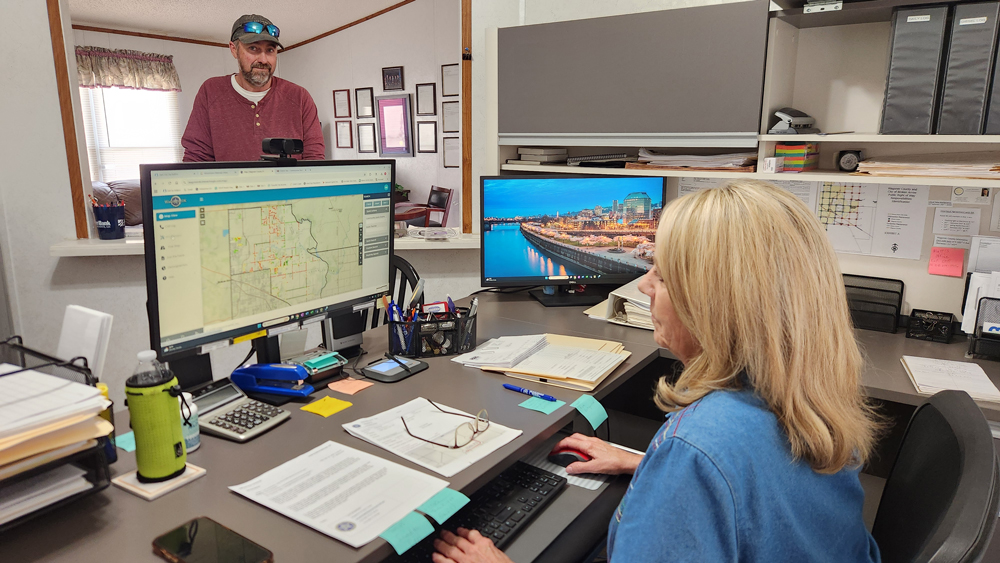 Commissioner James Hanning confers with his assistant, Carolyn, in county office