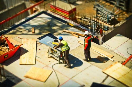 Generic work crews standing on plywood and working with building equipment