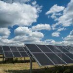 Solar panels on pasture with clouds overhead